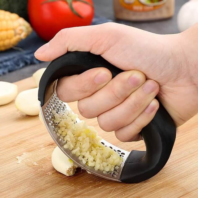 Stainless steel garlic onion rocker masher in use